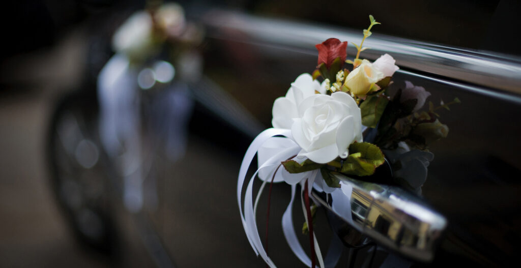 close up of wedding flowers tied to car