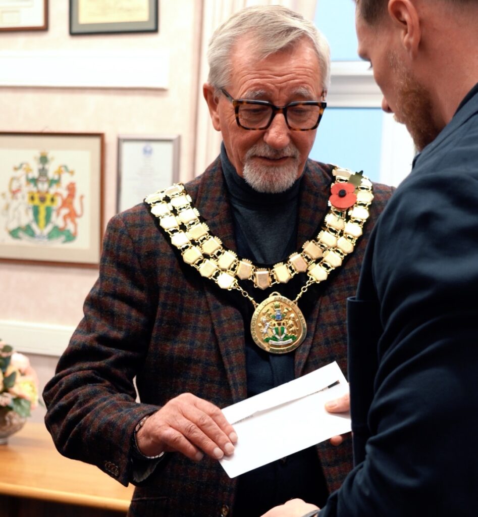 handing cheque envelope to mayor